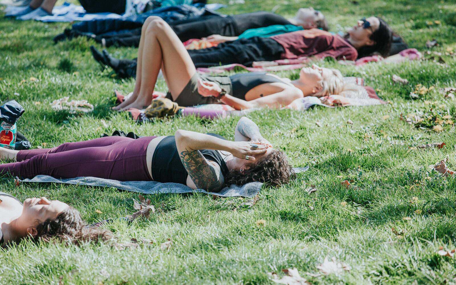 People lying on the grass in the sun at the end of a session